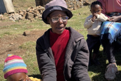 A villager reading her Bible with new glasses given by our team.
