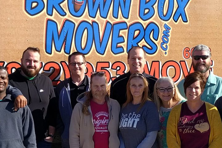 Staff of CrossRidge, Lovepacs, and Brown Box Movers standing front of Lovepacs delivery truck